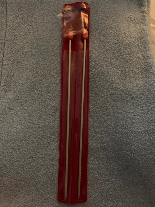 These are a pair of 3.25 mm knitting needles in their original red plastic packaging.