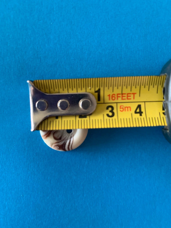 vintage-style plastic buttons with a cream and brown marbled/swirl pattern and 2 holes for sewing.