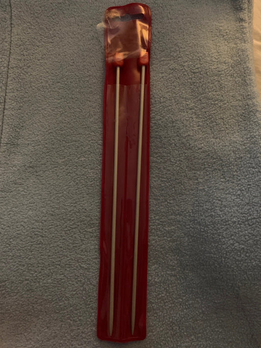 These are a pair of 3.25 mm knitting needles in their original red plastic packaging.