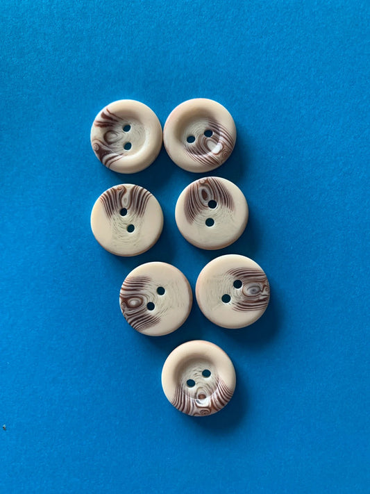 vintage-style plastic buttons with a cream and brown marbled/swirl pattern and 2 holes for sewing.